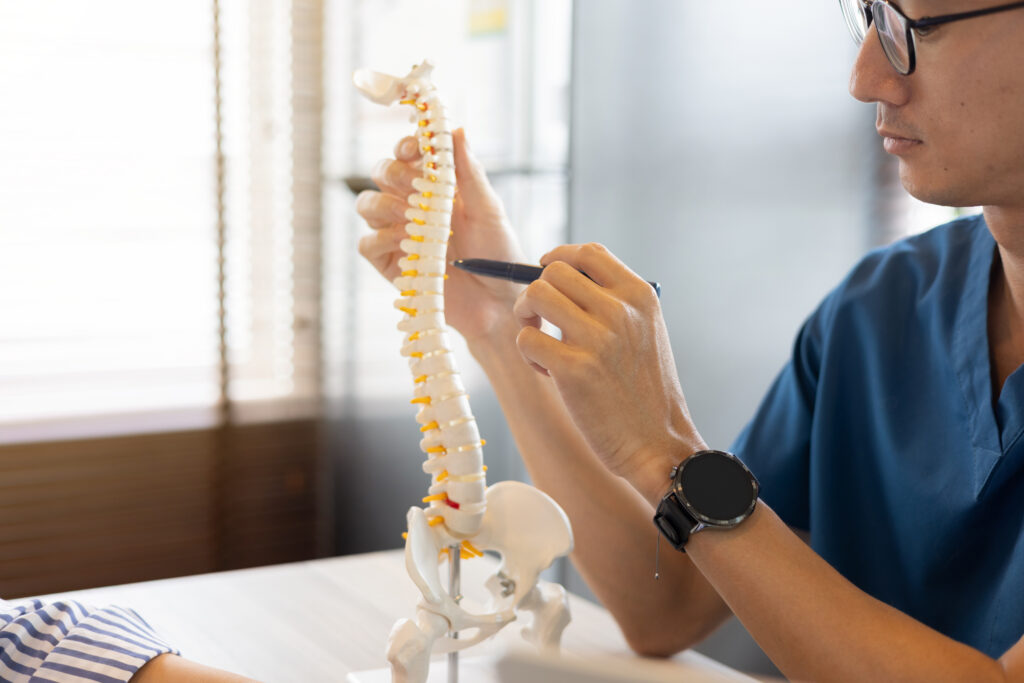 Chiropractor examining a patient's spine to diagnose the source of pain