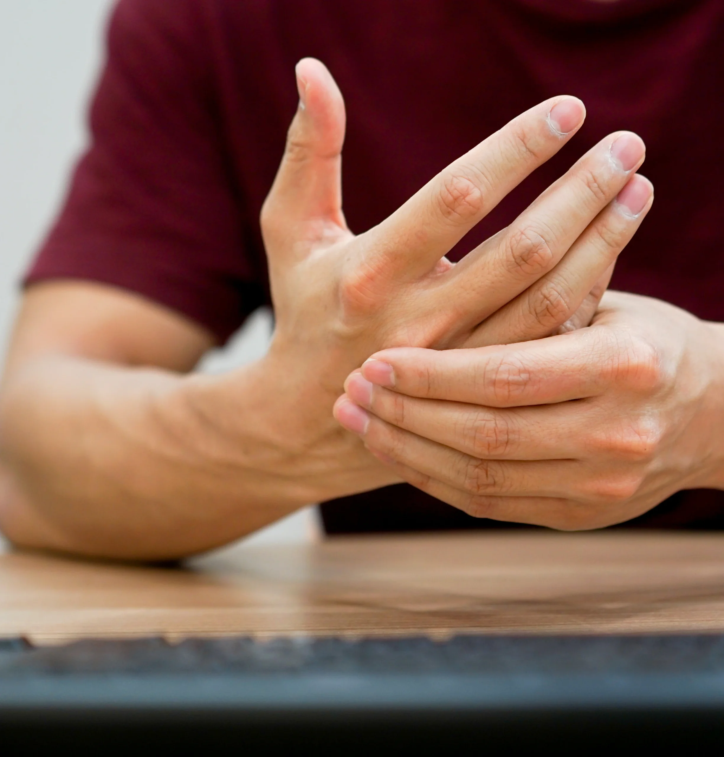 Person experiencing arm and hand pain associated with carpal tunnel syndrome