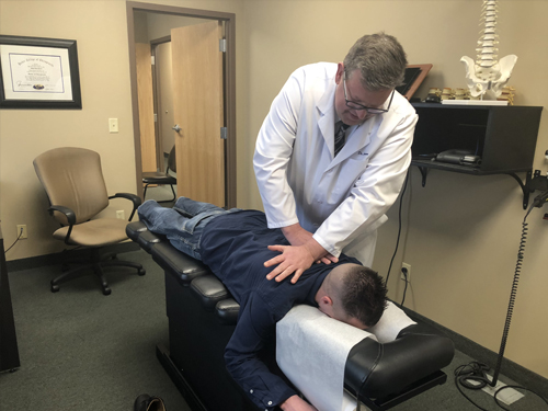 Dr. Daniel Larsen performing a chiropractic spinal adjustment on a patient at Twin Cities Chiropractic Spine and Injury Center