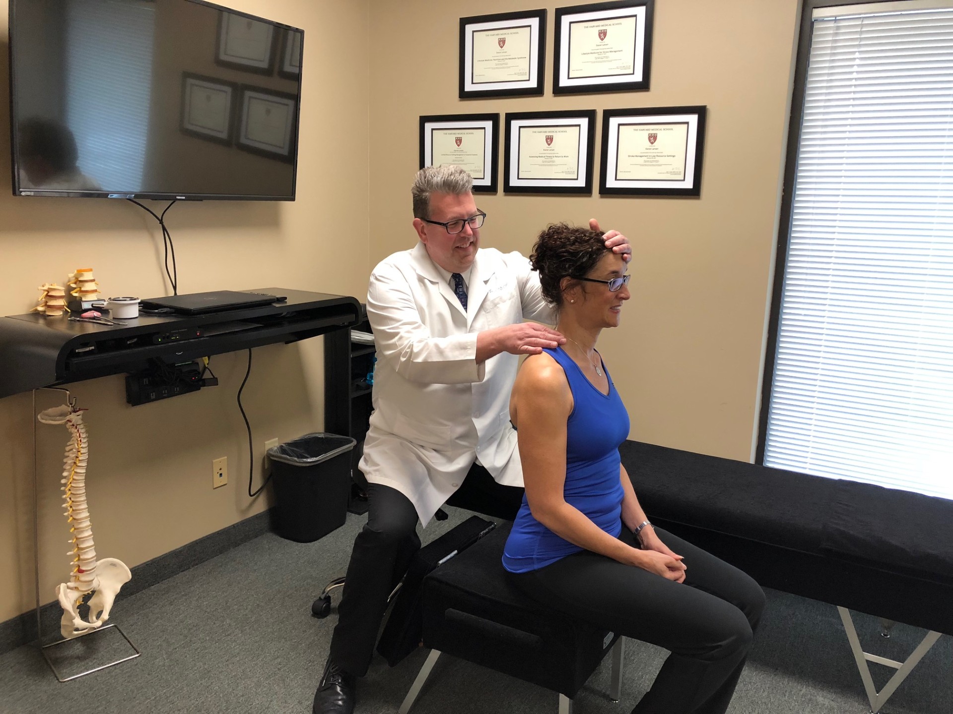 Dr. Daniel Larsen performing a seated cervical adjustment for neck pain at Twin Cities Chiropractic Spine and Injury Center