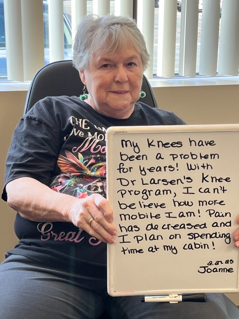 Patient Joanna holding a handwritten review of her experience at Twin Cities Chiropractic Spine and Injury Center