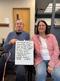 Patients Kathy and Wayne holding a handwritten review of their experience at Twin Cities Chiropractic Spine and Injury Center