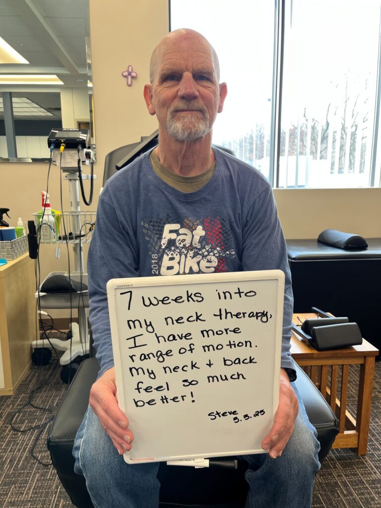 Patient Steve holding a handwritten review of his experience at Twin Cities Chiropractic Spine and Injury Center