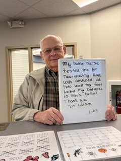 Patients Kathy and Wayne holding a handwritten review of their experience at Twin Cities Chiropractic Spine and Injury Center